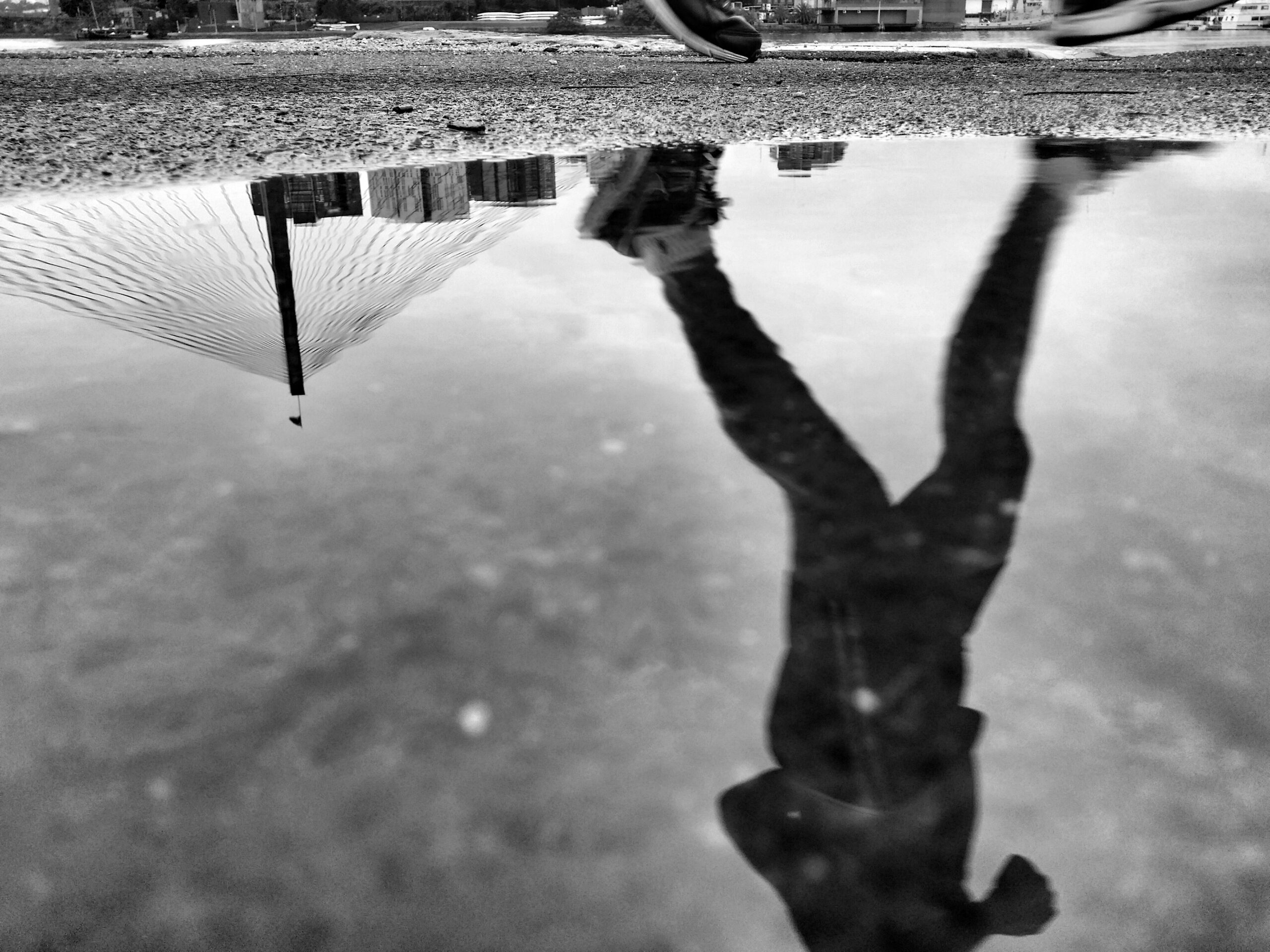 Reflection of a person walking, caught in a puddle